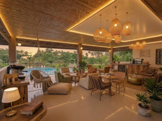 The guest lounge and café at dusk, rattan pendants over a timber bar