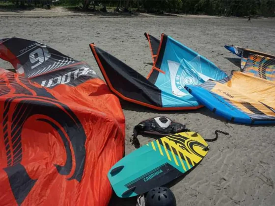 Kitesurfing kites and boards laid out on the sand