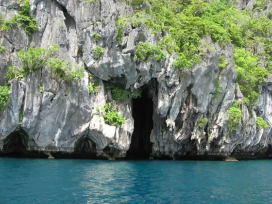 A limestone cliff and cave entrance