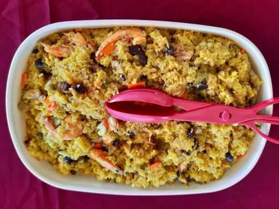 A dish of yellow seafood rice in a white bowl