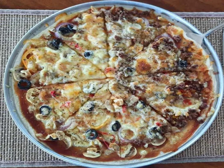A whole pizza on a white plate