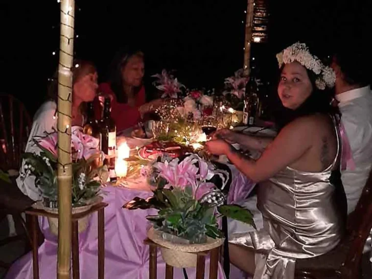Guests at a decorated long table at an evening function