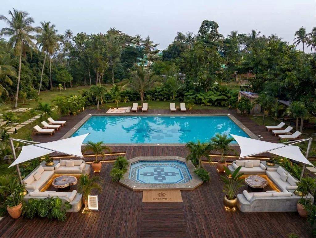 The pool deck and event lawn from above, sail shades over the sunken lounges