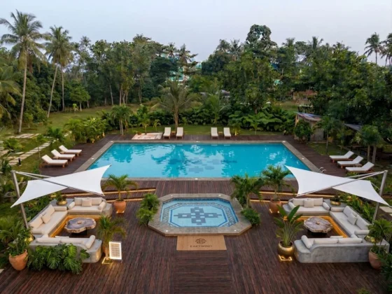 The pool deck from above with white sail shades over sunken lounges