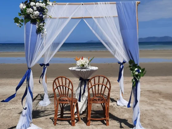 A table for two under white drapes on the beach